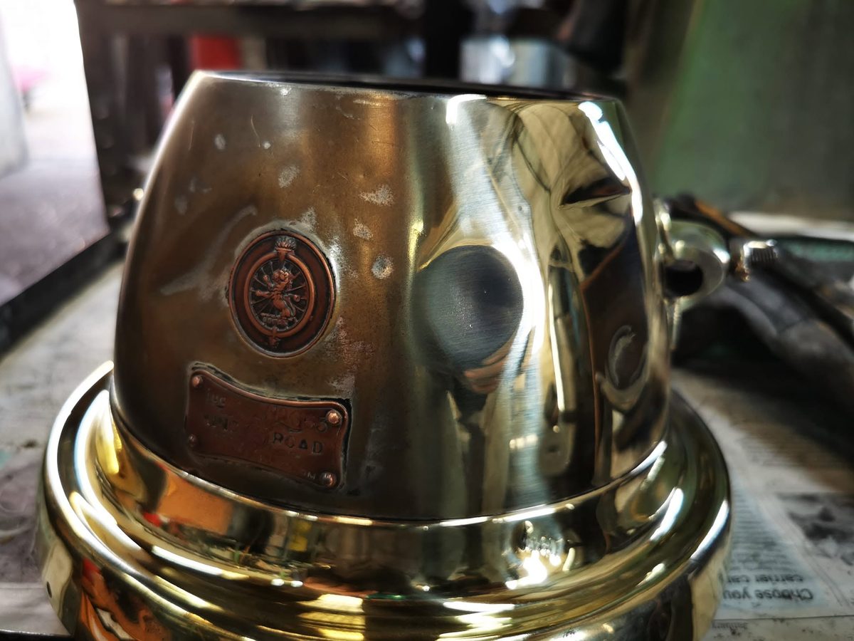 A brass lamp housing polished to a mirror finish
